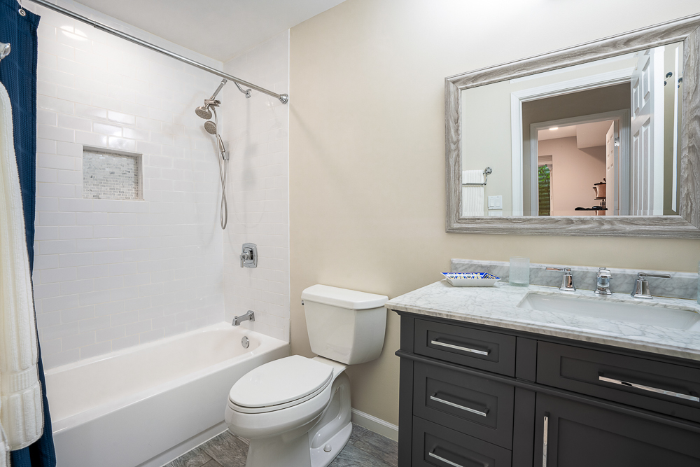 2028 Maple Avenue Northbrook, IL 60062 - Photo 15 of 26 a bathroom with a granite countertop toilet a sink and a bathtub
