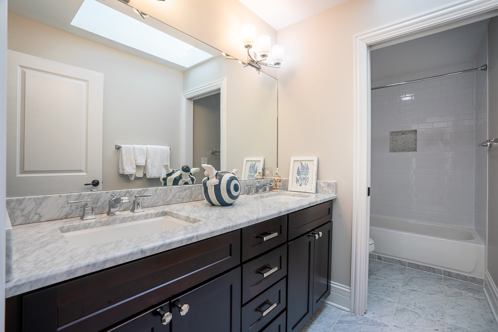 2028 Maple Avenue Northbrook, IL 60062 - Photo 18 of 26 a bathroom with a granite countertop sink double vanity and a mirror