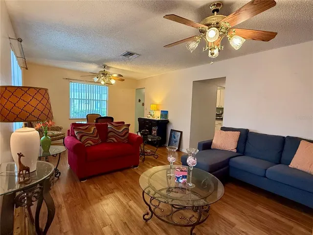 a living room with furniture a chandelier and a dining table