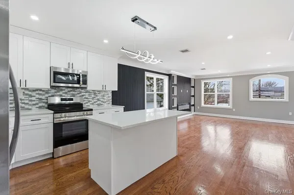 a kitchen with granite countertop a stove top oven a sink and a refrigerator