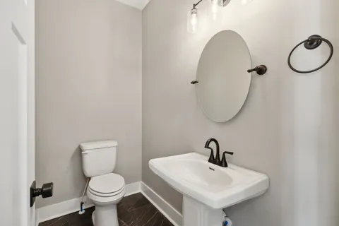 a bathroom with a sink a toilet and a mirror