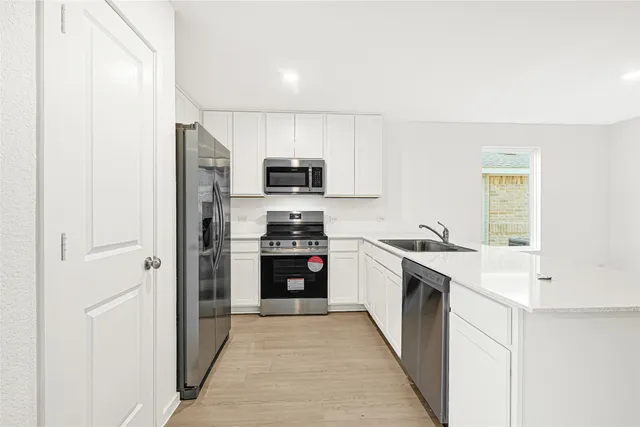 a kitchen with kitchen island a sink stove and refrigerator