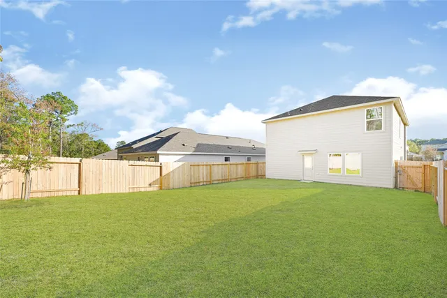 a view of a big house with a big yard and a large tree