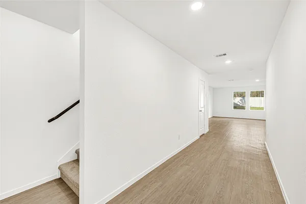 a view of a hallway with wooden floor