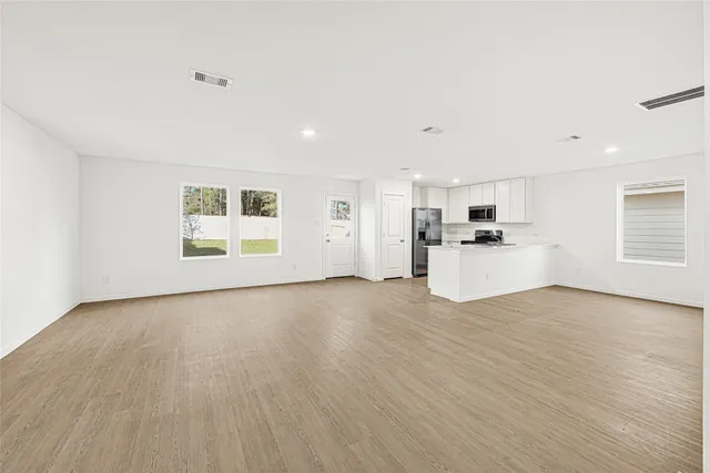 a view of a kitchen with a sink a refrigerator and window