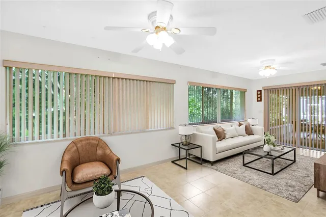 a living room with furniture and a large window with garden view