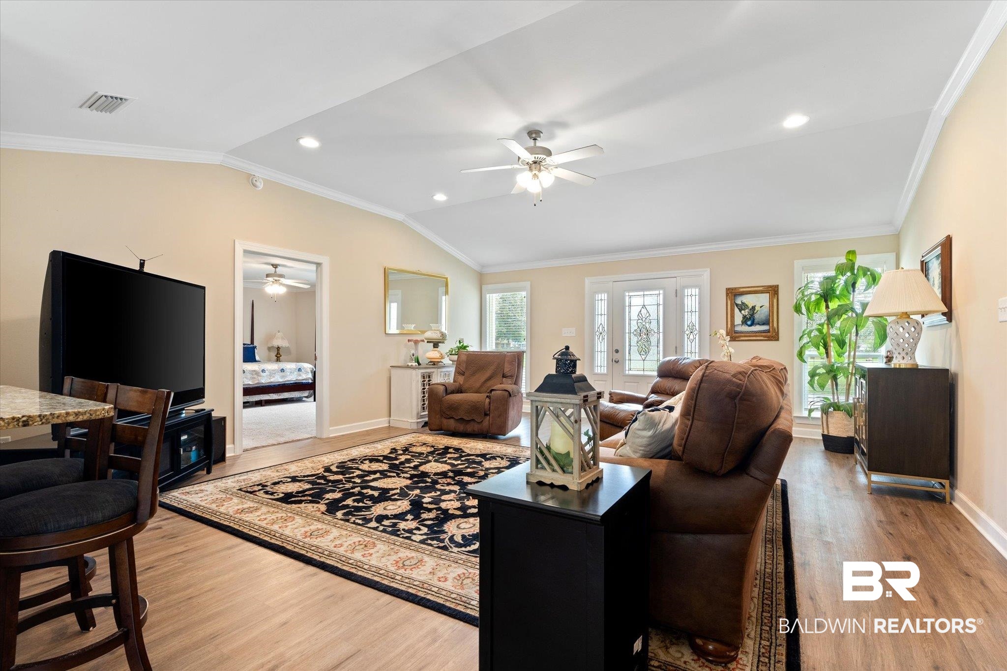 734 West Section Avenue Foley, AL 36535 - Photo 7 of 50 Living area with light wood finished floors, crown molding, baseboards, and vaulted ceiling