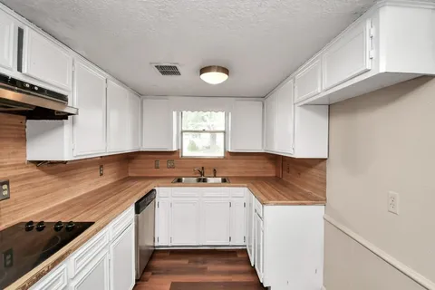 a view of a kitchen with sink and cabinets