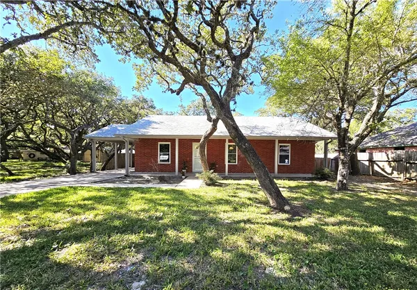 a front view of a house with yard and trees