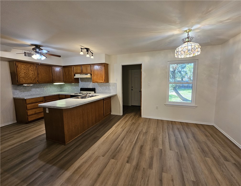 3121 Lenore Avenue Ingleside, TX 78362 - Photo 10 of 24 a kitchen with stainless steel appliances granite countertop a stove a sink dishwasher and a microwave oven with large wooden cabinets
