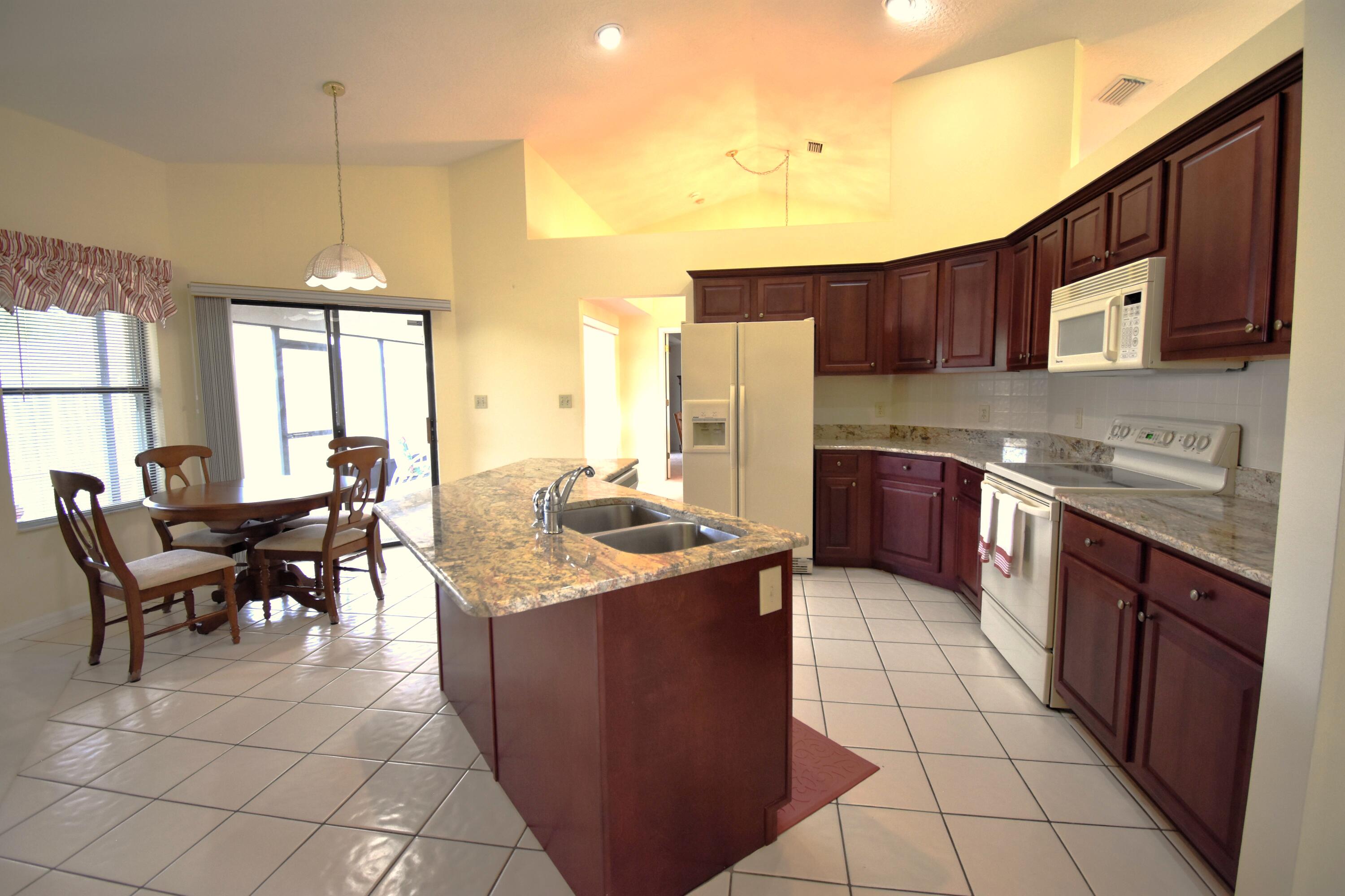 1920 Glen Meadows Circle Melbourne, FL 32935 - Photo 11 of 19 a kitchen with stainless steel appliances granite countertop a stove a sink a oven a dining table and chairs