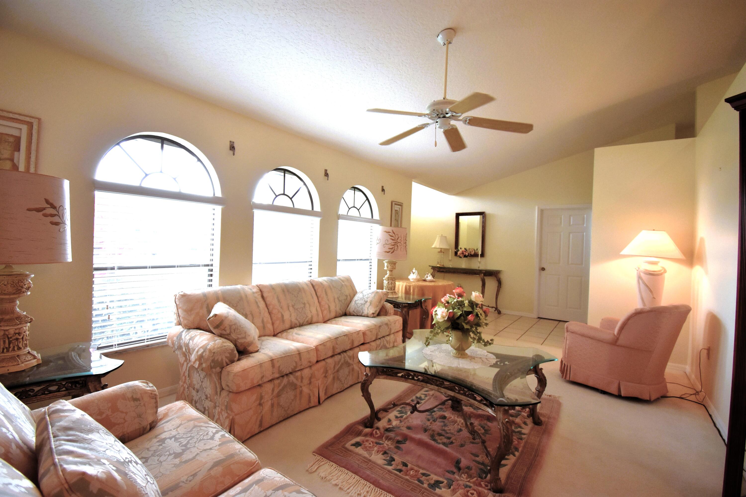 1920 Glen Meadows Circle Melbourne, FL 32935 - Photo 4 of 19 a living room with furniture a large window and a chandelier