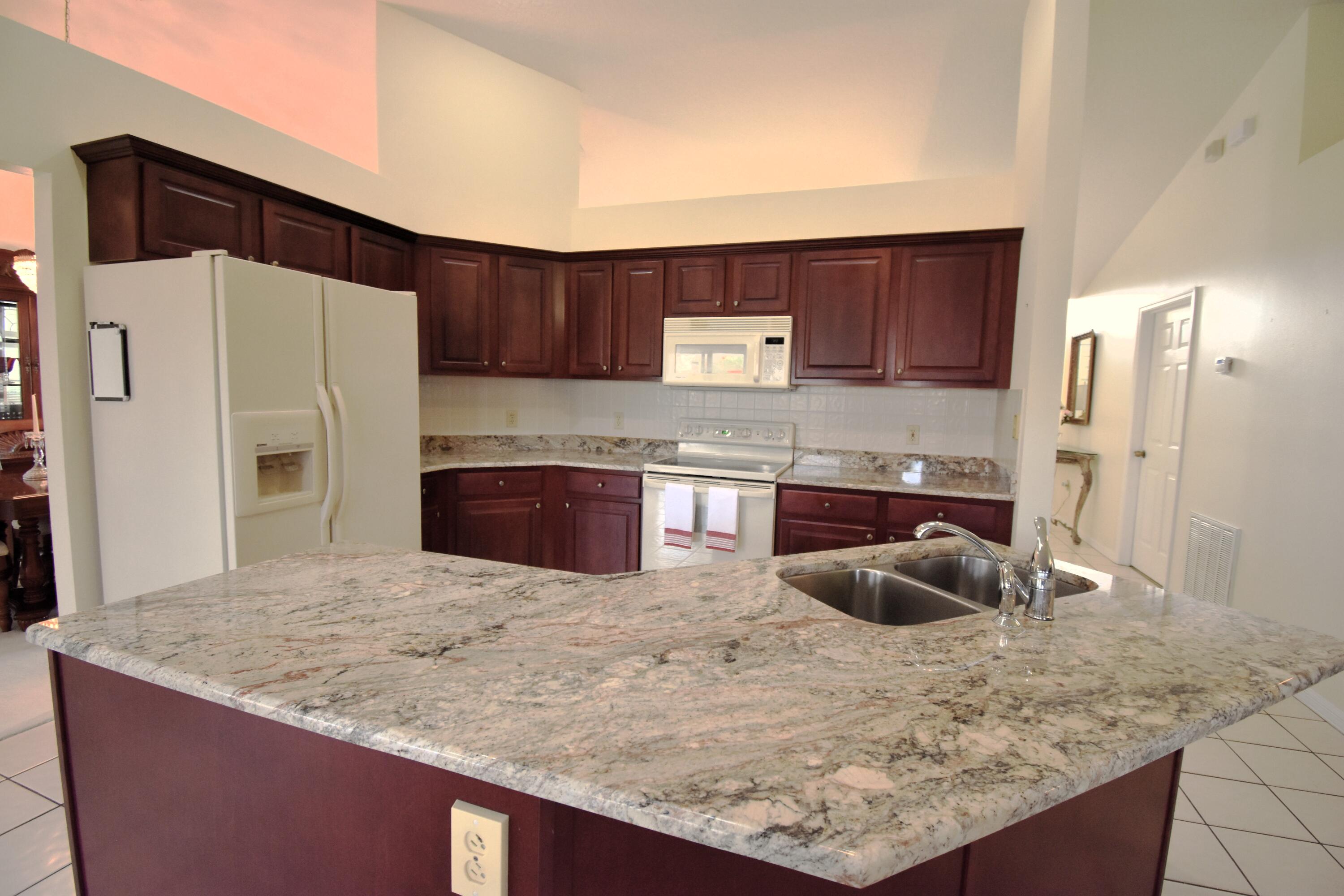 1920 Glen Meadows Circle Melbourne, FL 32935 - Photo 9 of 19 a kitchen with stainless steel appliances granite countertop a sink stove and refrigerator
