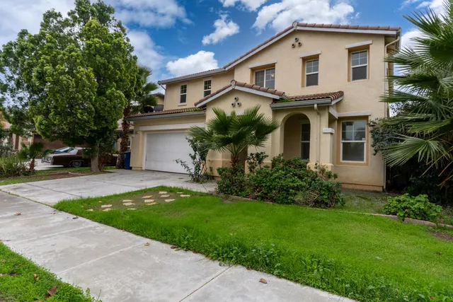 a front view of a house with a garden and plants