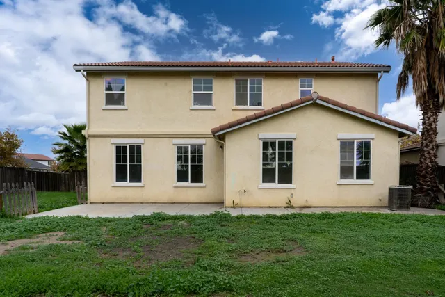 a view of backyard with potted plants and wooden fence