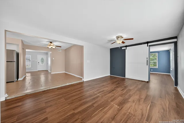 a view of a livingroom with wooden floor and a ceiling fan