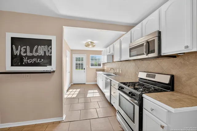 a kitchen with stainless steel appliances granite countertop a stove and a microwave