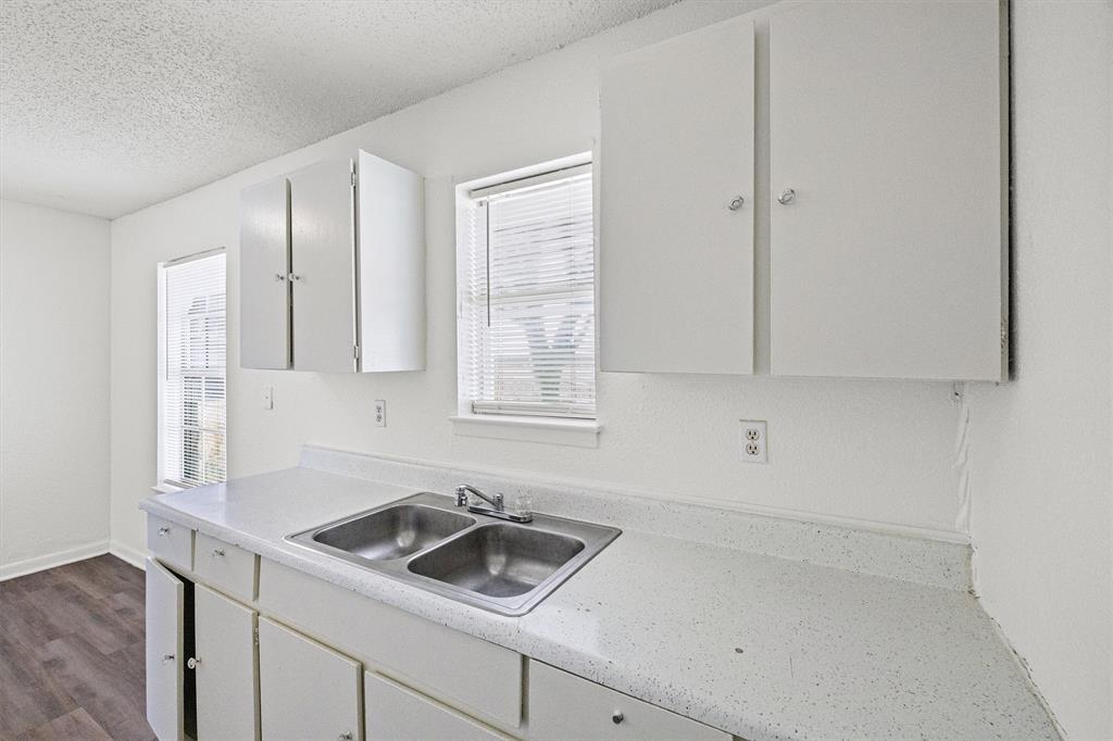 500 Highway 22 Meridian, TX 76665 - Photo 13 of 28 a kitchen with white cabinets and a sink