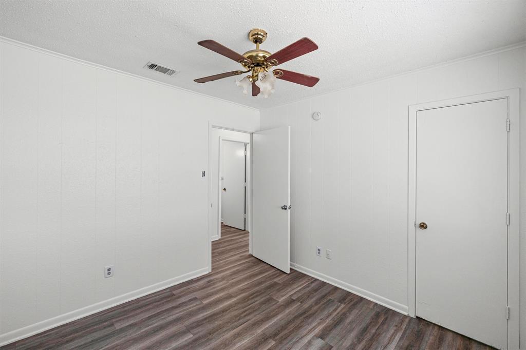 500 Highway 22 Meridian, TX 76665 - Photo 16 of 28 an empty room with wooden floor and ceiling fan