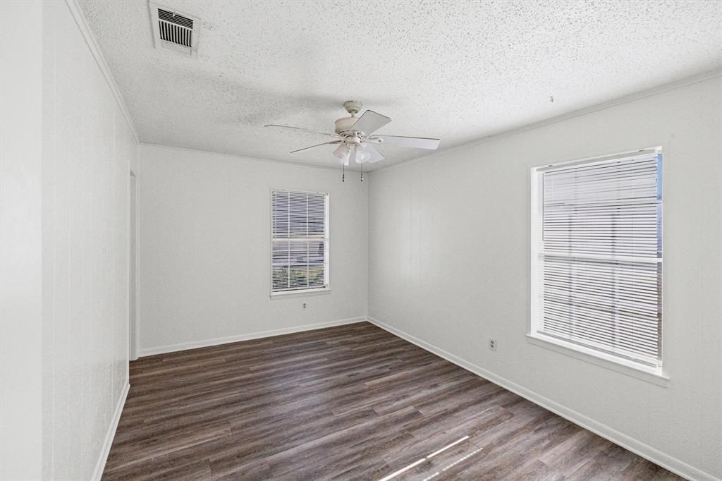 500 Highway 22 Meridian, TX 76665 - Photo 18 of 28 an empty room with wooden floor chandelier fan and windows
