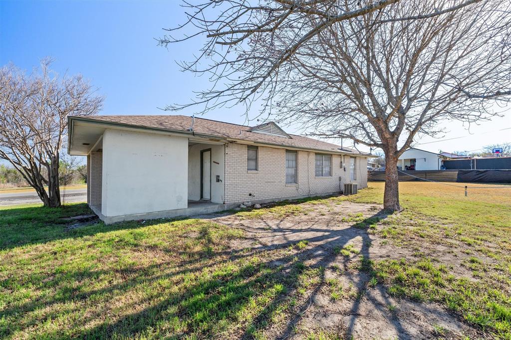 500 Highway 22 Meridian, TX 76665 - Photo 25 of 28 Rear view of property featuring brick siding and a yard