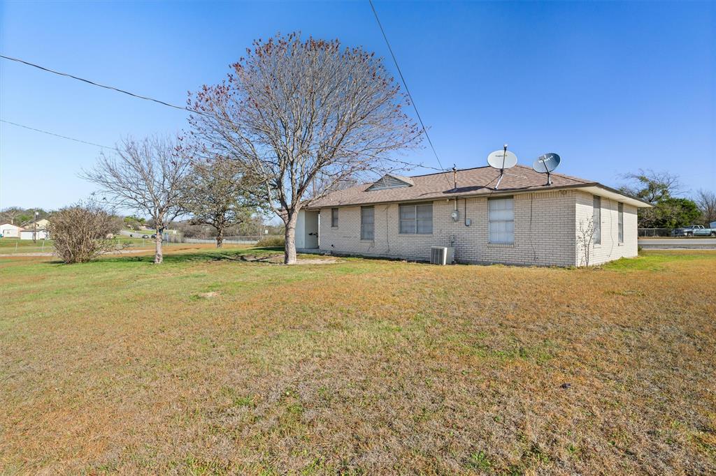 500 Highway 22 Meridian, TX 76665 - Photo 27 of 28 Rear view of property with brick siding and a yard