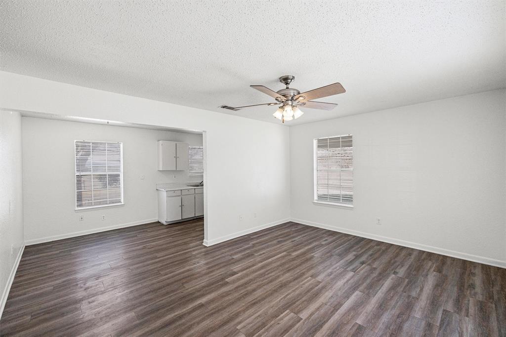 500 Highway 22 Meridian, TX 76665 - Photo 6 of 28 an empty room with wooden floor chandelier fan and windows