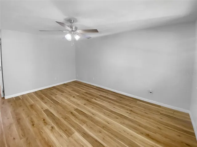 a view of a room with wooden floor and a ceiling fan