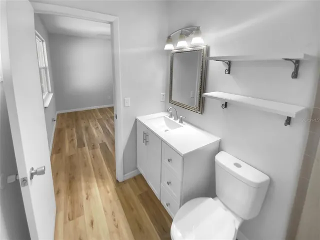 a bathroom with a sink mirror vanity and toilet