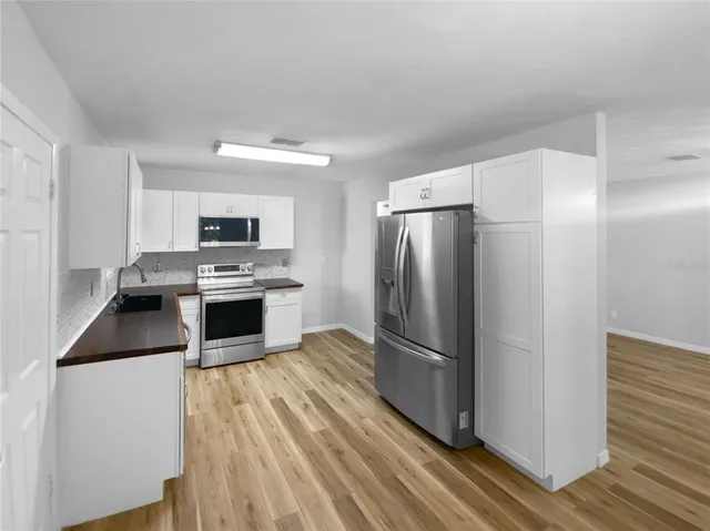 a kitchen with stainless steel appliances a refrigerator sink and microwave