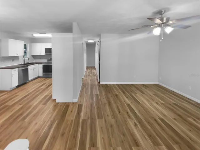 a view of a kitchen with wooden floor and a sink