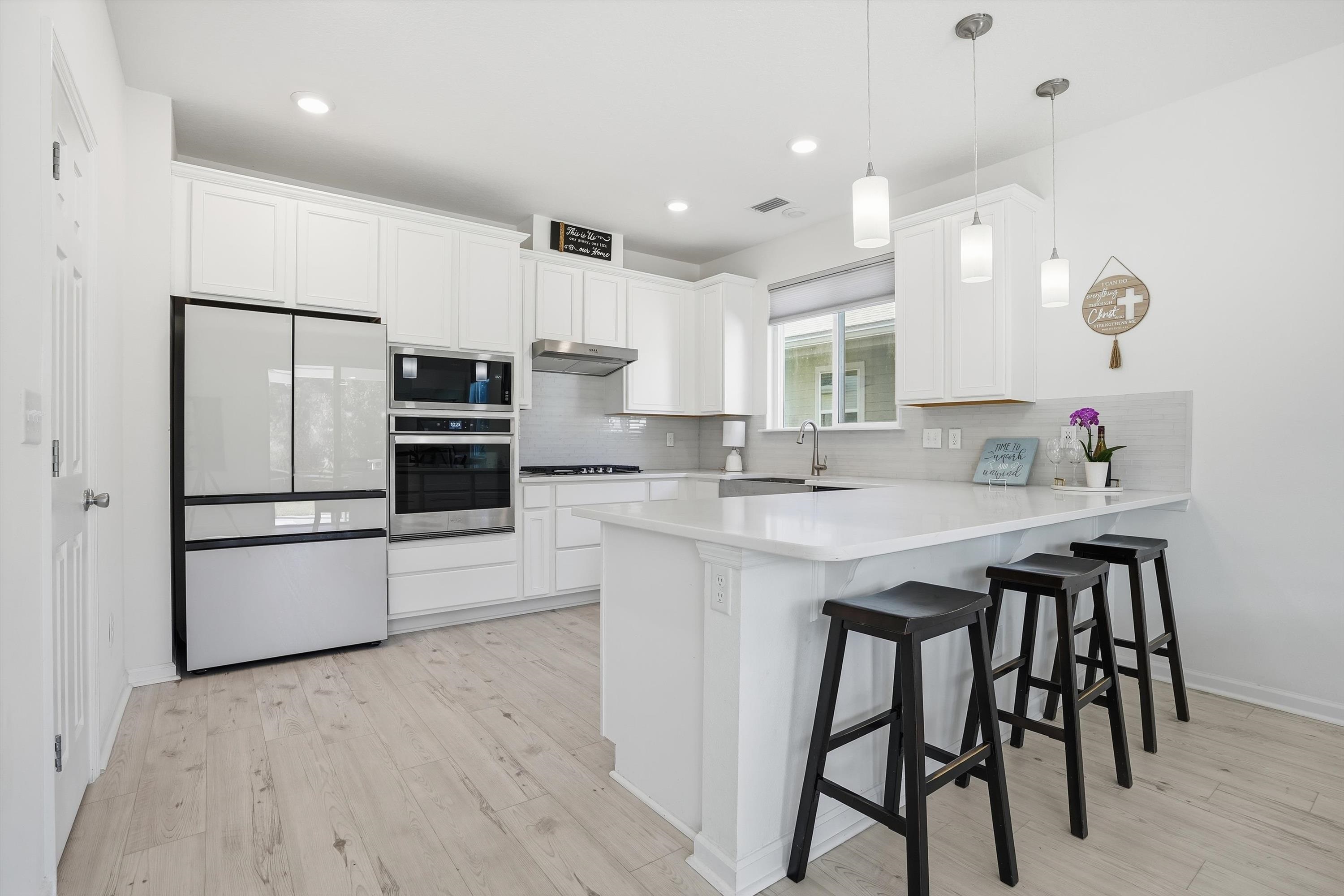 358 Rambling Brk Trail St. Johns, FL 32259 - Photo 13 of 39 a kitchen with stainless steel appliances a sink a stove a refrigerator and island with wooden floor
