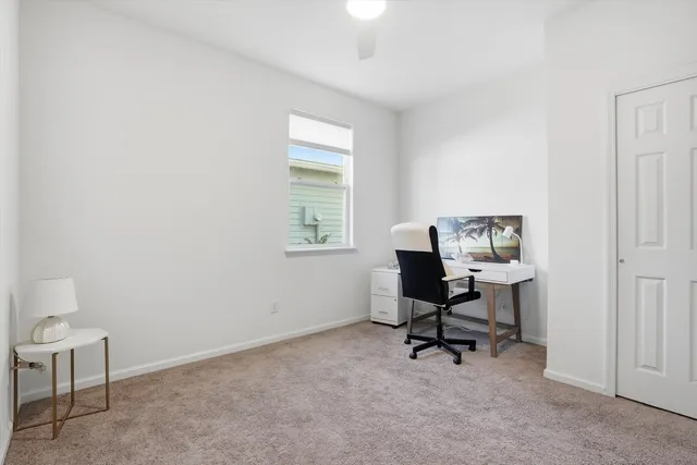 a view of a workspace with furniture and a window