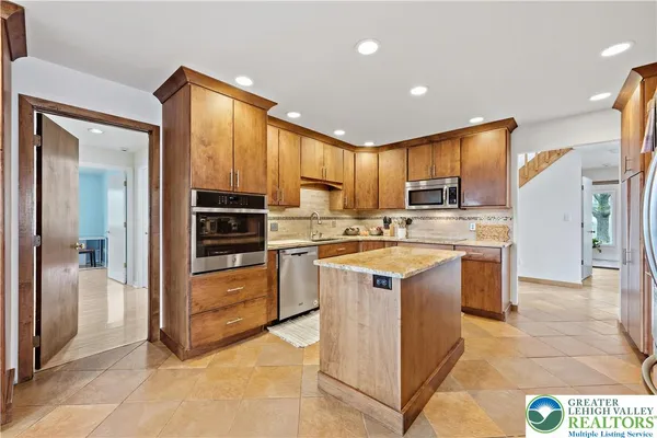 a kitchen with stainless steel appliances granite countertop a stove top oven a sink dishwasher and cabinets with wooden floor