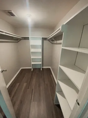 a view of walk in closet with empty racks