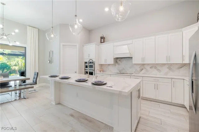 a kitchen with kitchen island granite countertop a sink stainless steel appliances and cabinets
