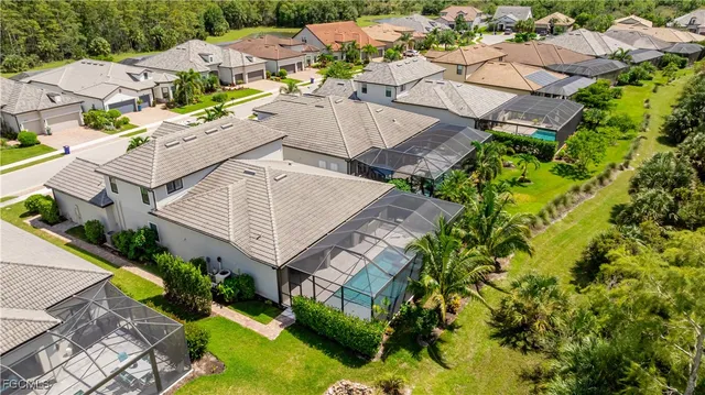 an aerial view of a house with swimming pool and large trees