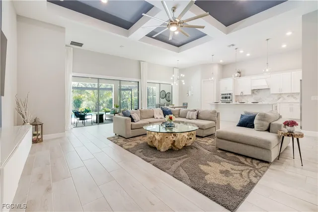 a living room with couches and kitchen view with wooden floor