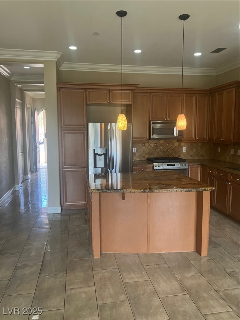 32 Via Vasari, Unit 103 Henderson, NV 89011 - Photo 8 of 26 Kitchen with ornamental molding, range, a kitchen island, and stainless steel refrigerator with ice dispenser