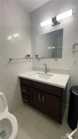 a bathroom with a sink vanity mirror and toilet
