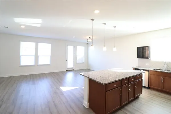 a kitchen with a sink cabinets and wooden floor