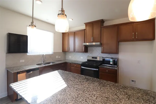 a kitchen with a sink a stove and a refrigerator