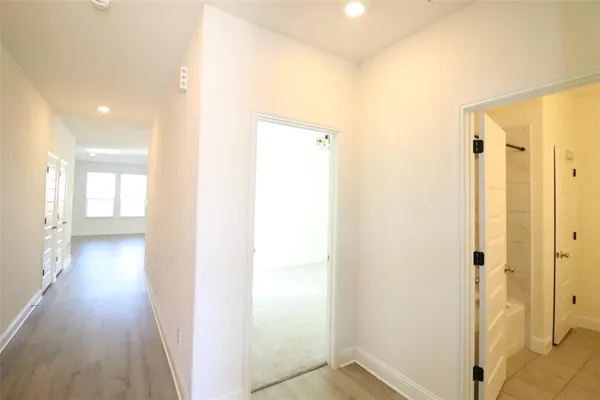 a view of a hallway with wooden floor