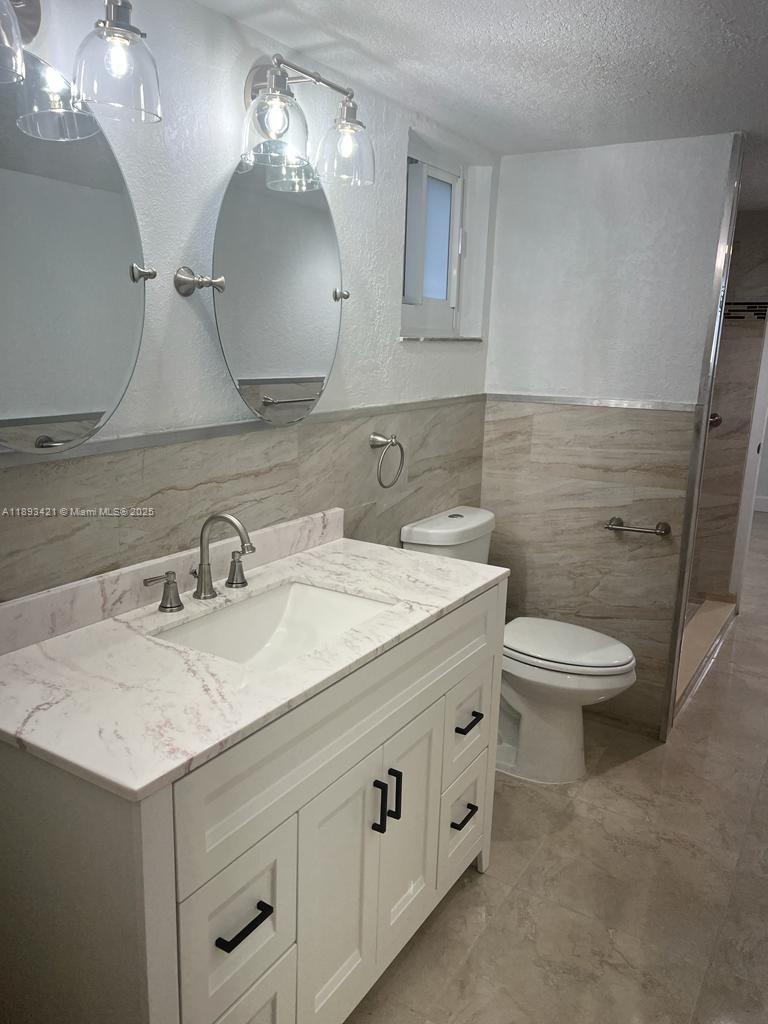 2670 West 76th Street, Unit 101 Hialeah, FL 33016 - Photo 17 of 35 a bathroom with a sink a toilet and a mirror