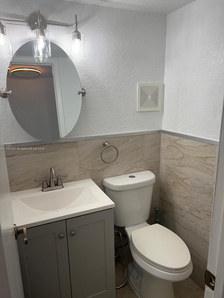2670 West 76th Street, Unit 101 Hialeah, FL 33016 - Photo 25 of 35 a bathroom with a toilet a sink and mirror