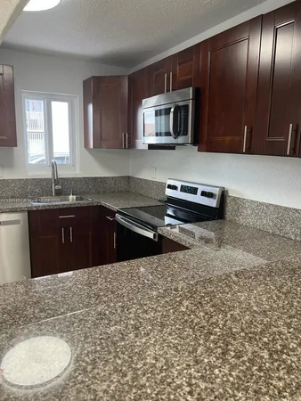 a kitchen with stainless steel appliances granite countertop a sink stove and microwave