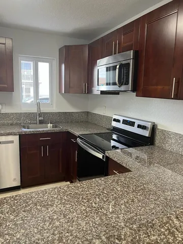 a kitchen with a sink stove and microwave