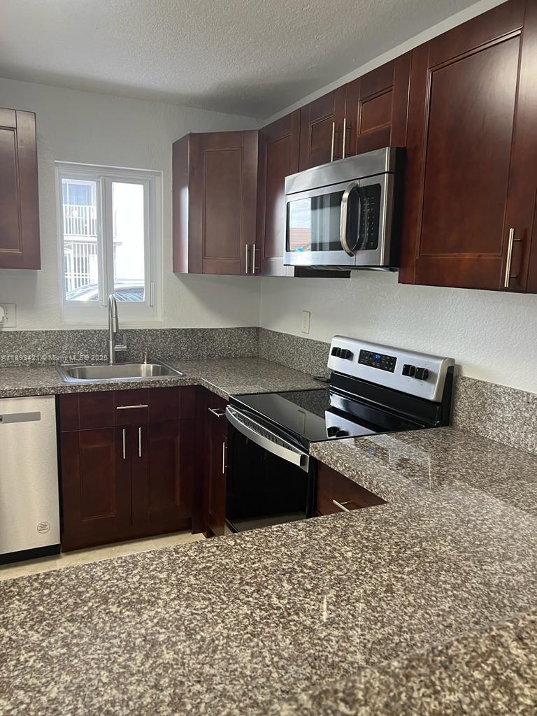 2670 West 76th Street, Unit 101 Hialeah, FL 33016 - Photo 7 of 35 a kitchen with a sink stove and microwave