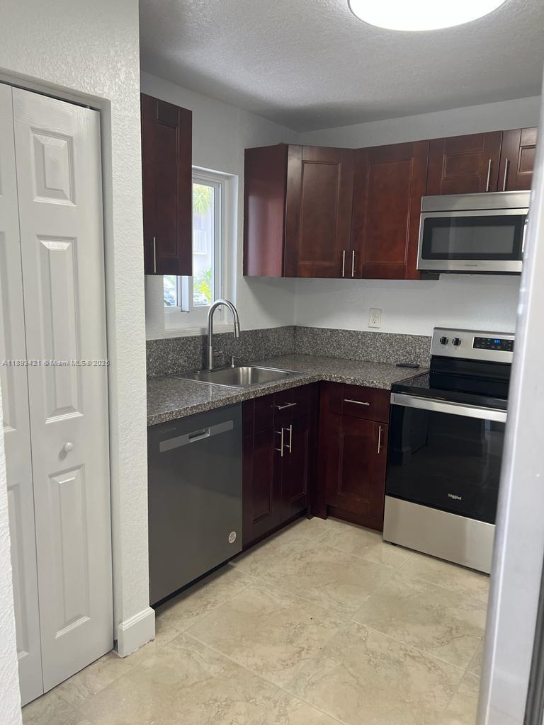 2670 West 76th Street, Unit 101 Hialeah, FL 33016 - Photo 8 of 35 a kitchen with stainless steel appliances granite countertop a stove a sink and a refrigerator