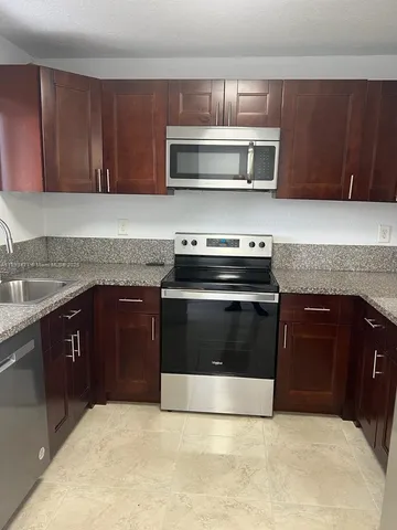 a kitchen with granite countertop a stove and a microwave